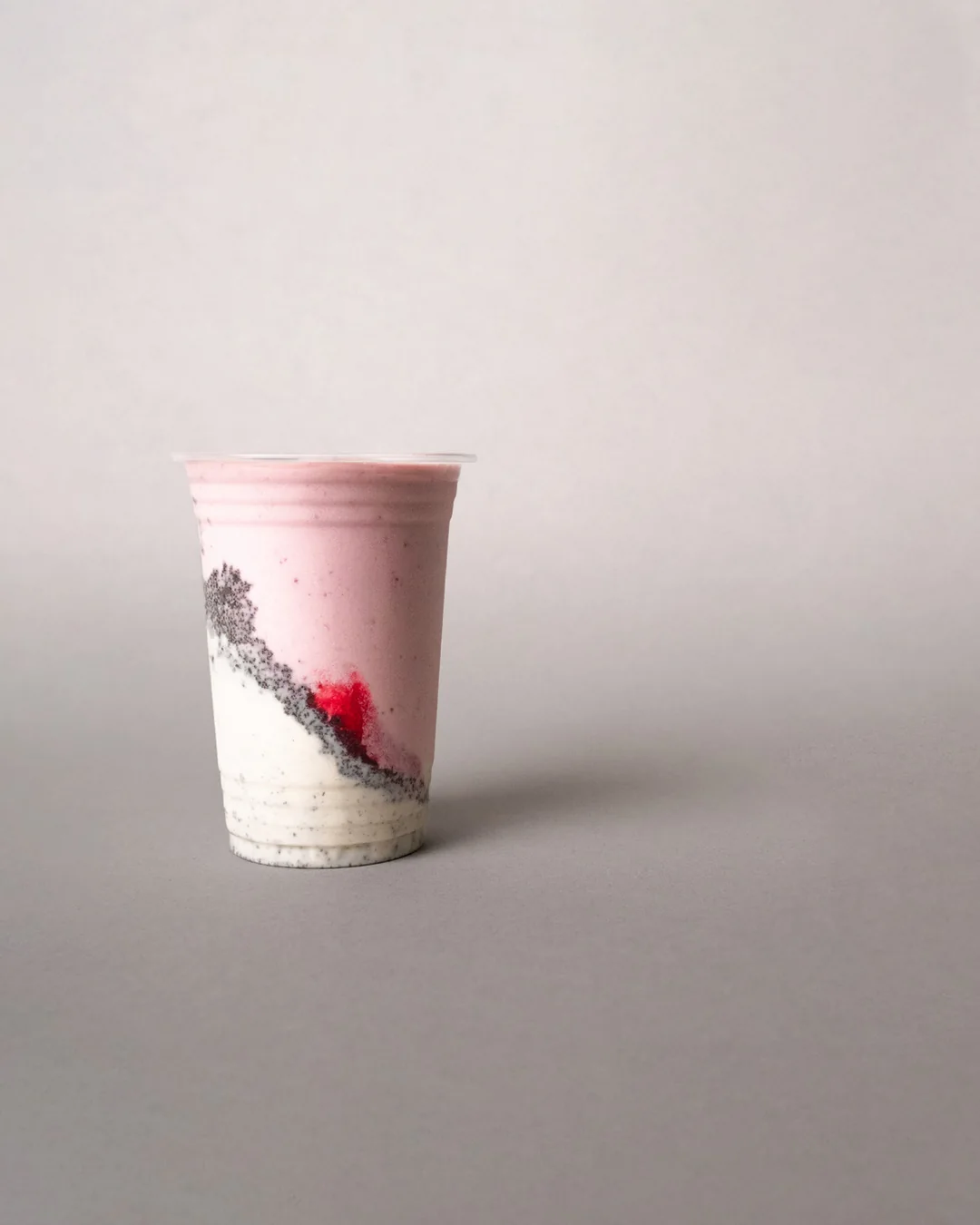 A MYLK berry and cream drink on a pale ground