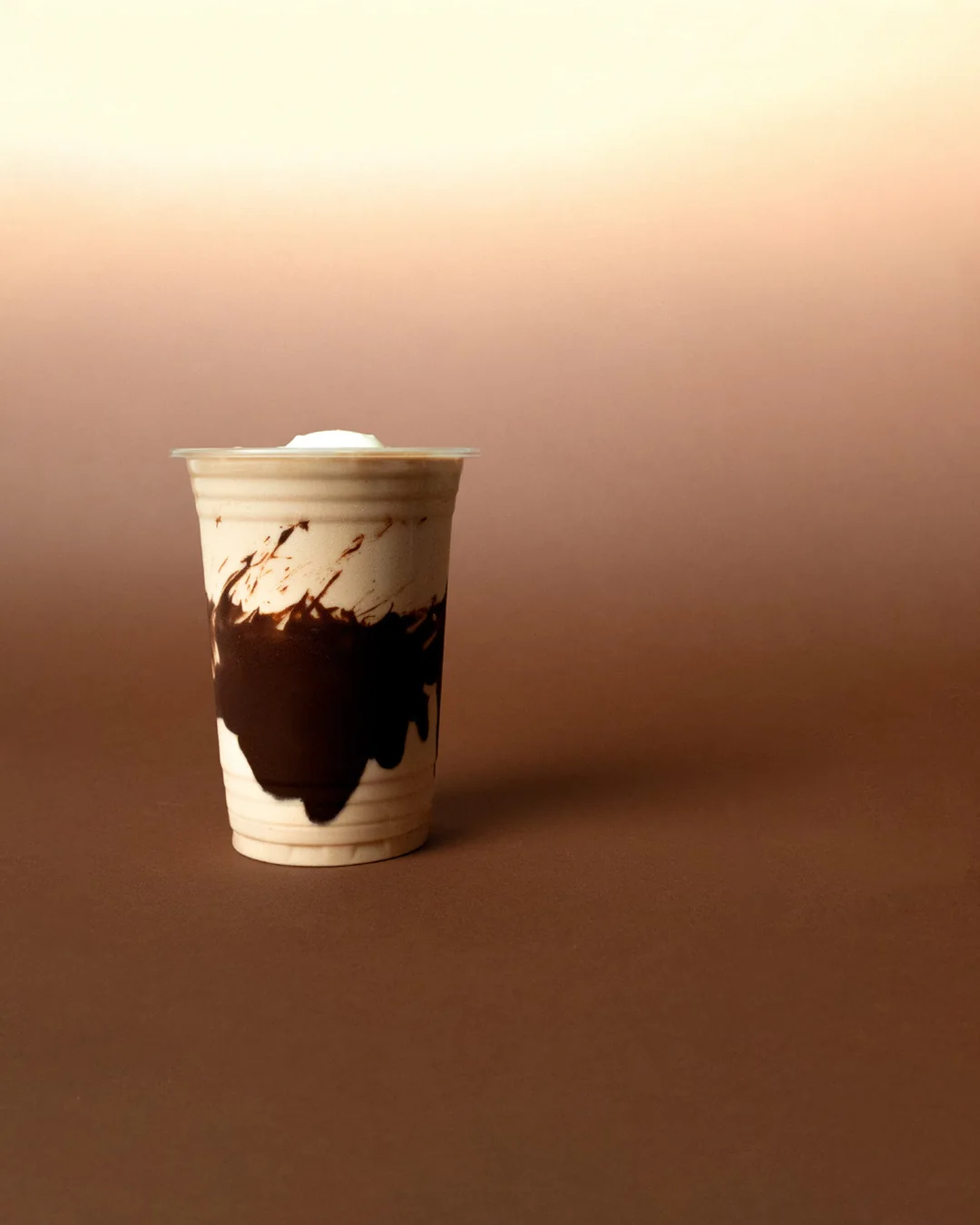 A MYLK cocoa drink on a warm brown ground